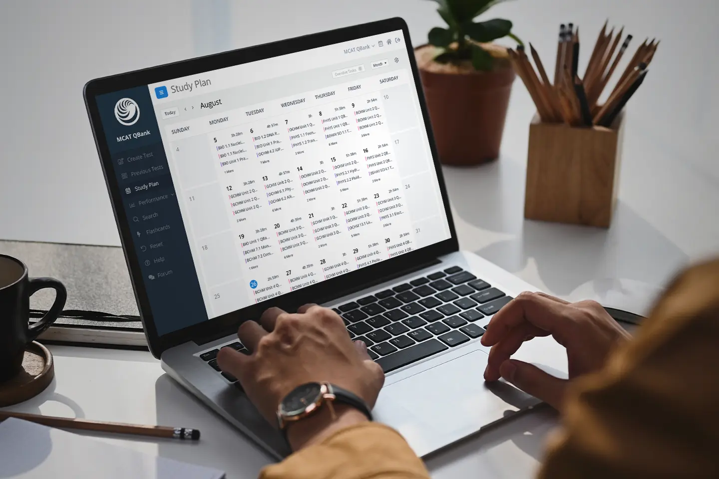 A person using a laptop showing UWorld's Study Planner with a calendar and study tasks