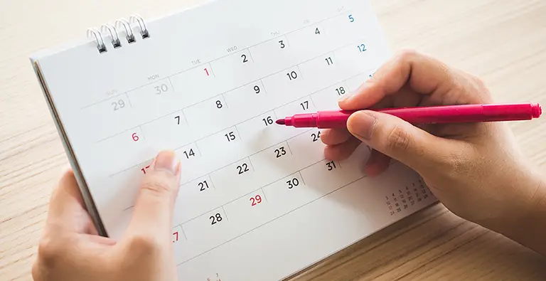 Student writing their MCAT test date on a calendar